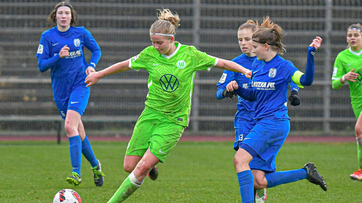 Eine Juniorin des VfL Wolfsburg in der U17 versucht sich bei ihren Gegnerinnen durchzuschlagen.