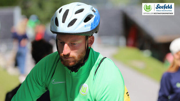 Maximilian Arnold vom VfL Wolfsburg auf dem Rad mit Fahrradhelm. 