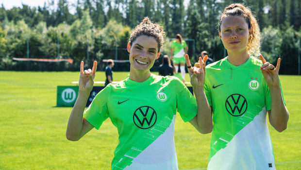 Die VfL-Wolfsburg-Spielerinnen Dominique Janssen und Fenna Kalma lachen in die Kamera.