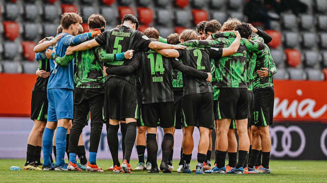 Die U19 vom VfL Wolfsburg steht im Kreis zusammen.