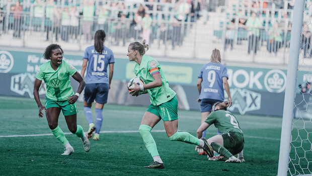 Lineth Beerensteyn und Alexandra Popp vom VfL Wolfsburg freuen sich. Rechts ist das Tor zu sehen. Popp hält den Ball in der Hand.