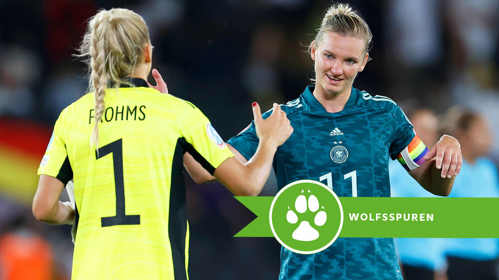 Merle Frohms und Alexandra Popp klatschen sich ein. Über dem Bild befindet sich eine VfL Wolfsburg Grafik mit einem Pfotenabdruck und der Aufschrift "Wolfsspuren".