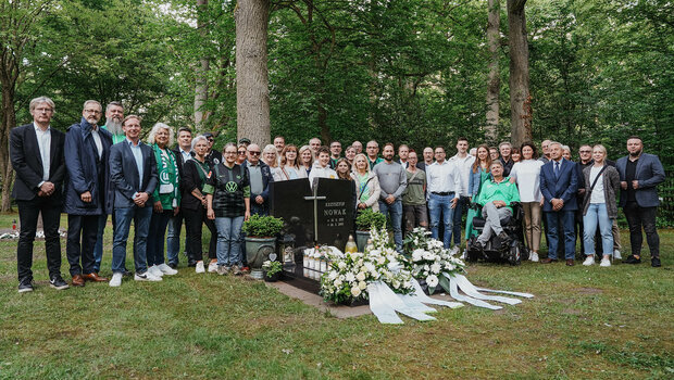 Fans, Familie und Vertreter des VfL posieren am Grab von Krzysztof Nowak.