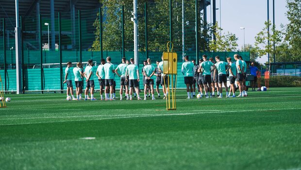 Das Team vom VfL Wolfsburg versammelt sich im Kreis auf dem Trainingsplatz.