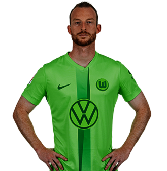 Der VfL Wolfsburg Spieler Maximilian Arnold posiert mit den Händen in der Hüfte.