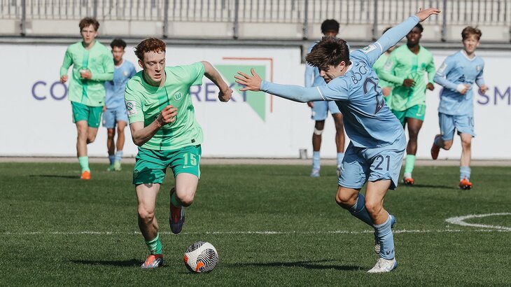 Ein Spieler der U17-Mannschaft des VfL Wolfsburg um Laufduell mit einem Gegenspieler.