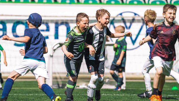 Jungs in verschiedenen Trikots freuen sich lautstark beim Grundschulfestival des VfL Wolfsburg.