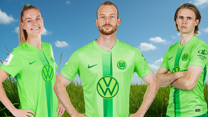 Eine VfL-Wolfsburg-Grafik mit Arnold, Wimmer und Minge, die vor einer Wiese stehen