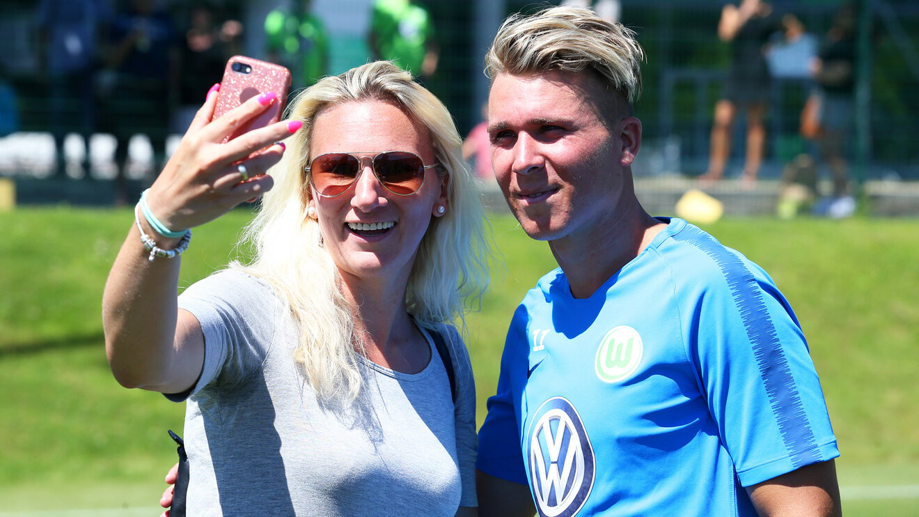 VfL Wolfsburg Spieler macht Fotos mit Fans.