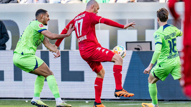 Die VfL Wolfsburg Spieler Jakub Kaminski und Maxence Lacroix verteidigen den Ball.