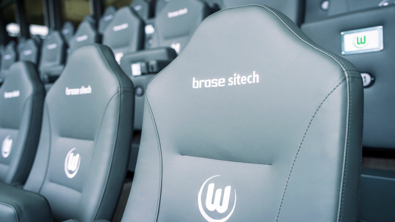 Graue Sitze mit der Aufschrift Brose Sitech und einem aufgestickten VfL Wolfsburg-Logo.