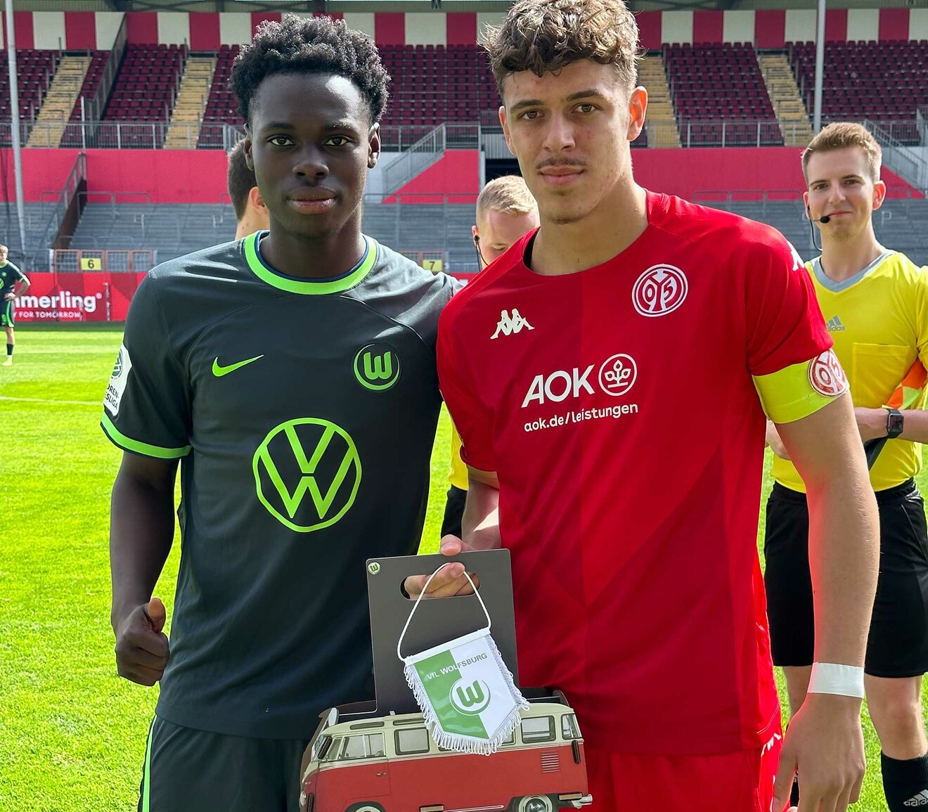 VfL-Wolfsburg-Spieler der U19 übergibt ein Geschenk an den Kapitän des FSV Mainz 05.