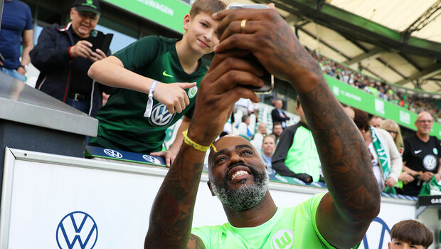Der ehemalige VfL Wolfsburg Spieler Grafite macht ein Selfie mit einem kleinen Fan in der Nordkurve der Volkswagen Arena.
