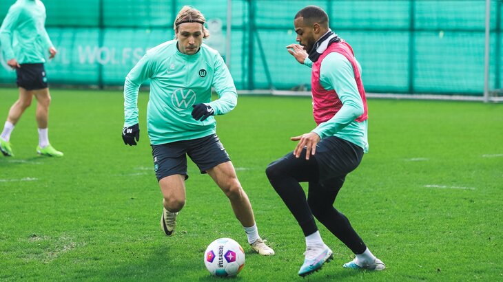 Die VfL-Wolfsburg-Spieler Lovro Majer und Lukas Nmecha konkurrieren im Training um den Ball.