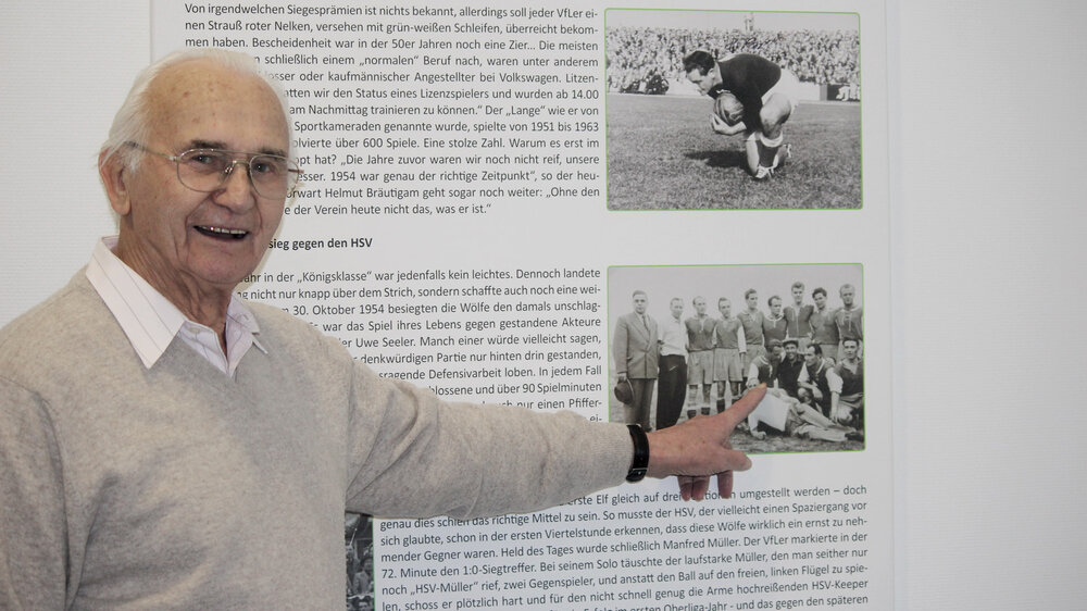 Der ehemalige VfL Wolfsburg-Spieler Alfred Heider zeigt auf ein altes Mannschaftsbild.