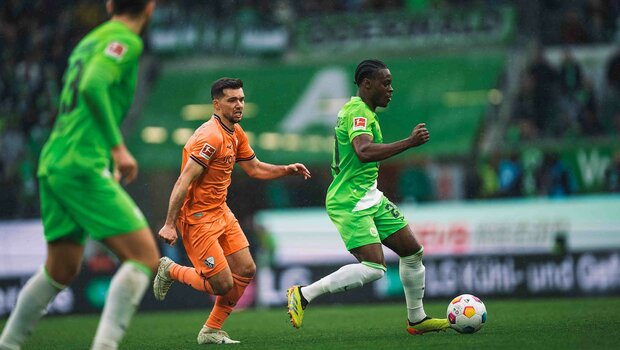 VfL-Wolfsburg-Spieler Ridle Baku im Kampf um den Ball mit Gegenspielern.