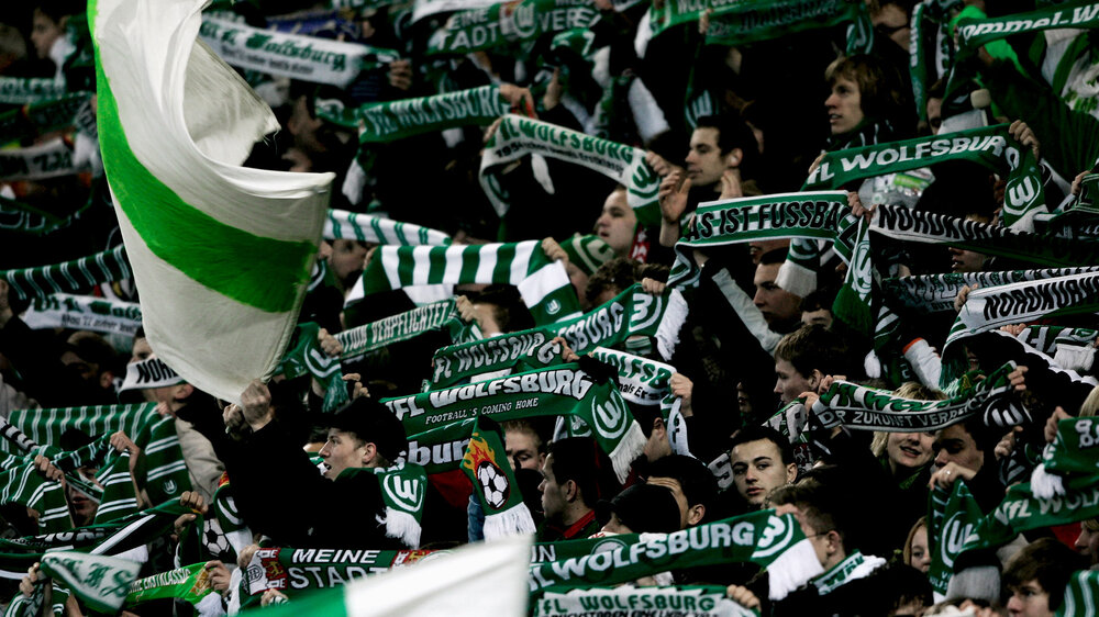 Die Fans halten ihre grün-weißen Schals nach oben.