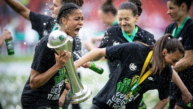 Die Spielerin des VfL Wolfsburg Sveindis Jonsdottir trägt den DFB-Pokal über den Rasen.