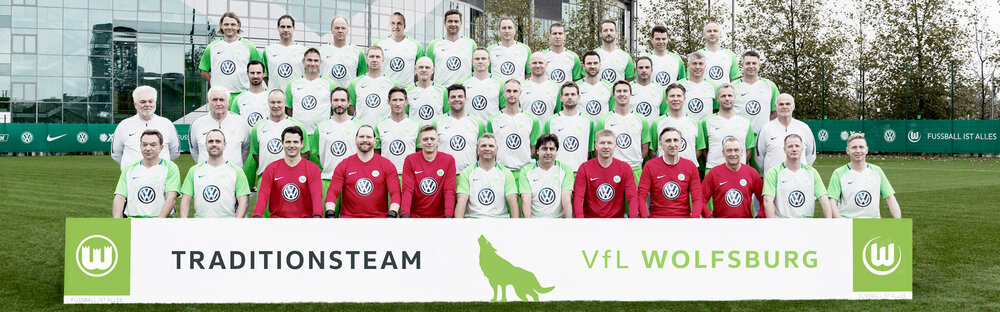 Das Traditionsteam des VfL Wolfsburg stellt ein Mannschaftsfoto vor dem Stadion.