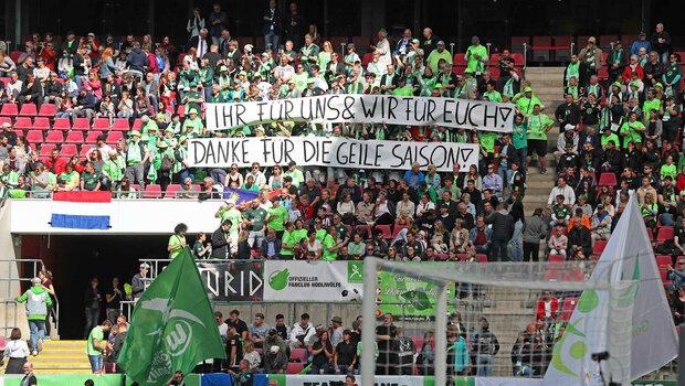 Die Fans des VfL Wolfsburg im Rein-Energie-Stadion mit einem Spruchband. 