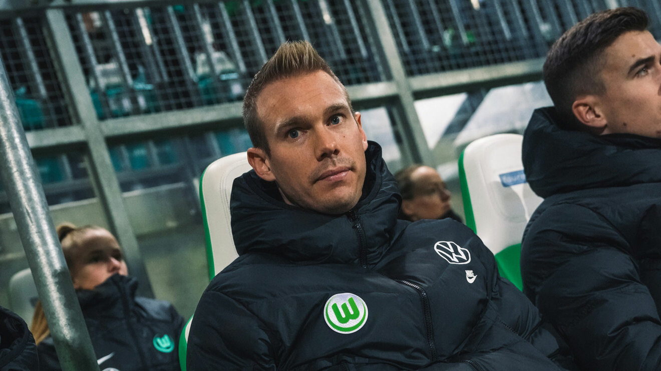 Der VfL-Wolfsburg-Trainer Tommy Stroot sitzt auf der Bank.