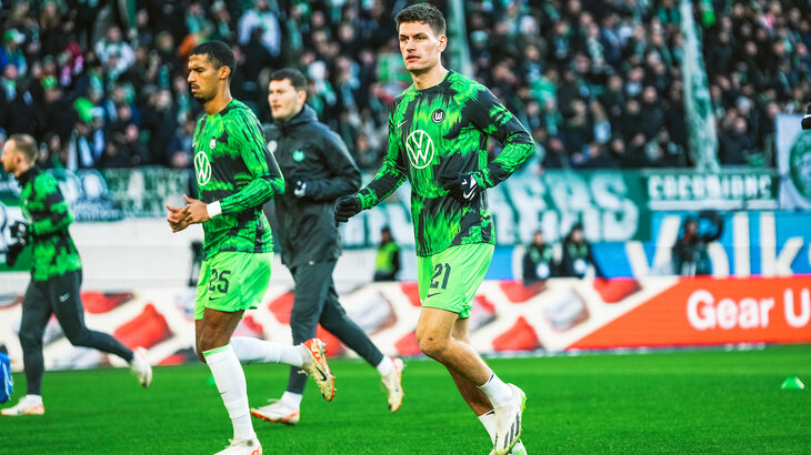 VfL Wolfsburg Spieler Maele wärmt sich vor einem Spiel auf dem Rasen der Volkswagen Arena auf.