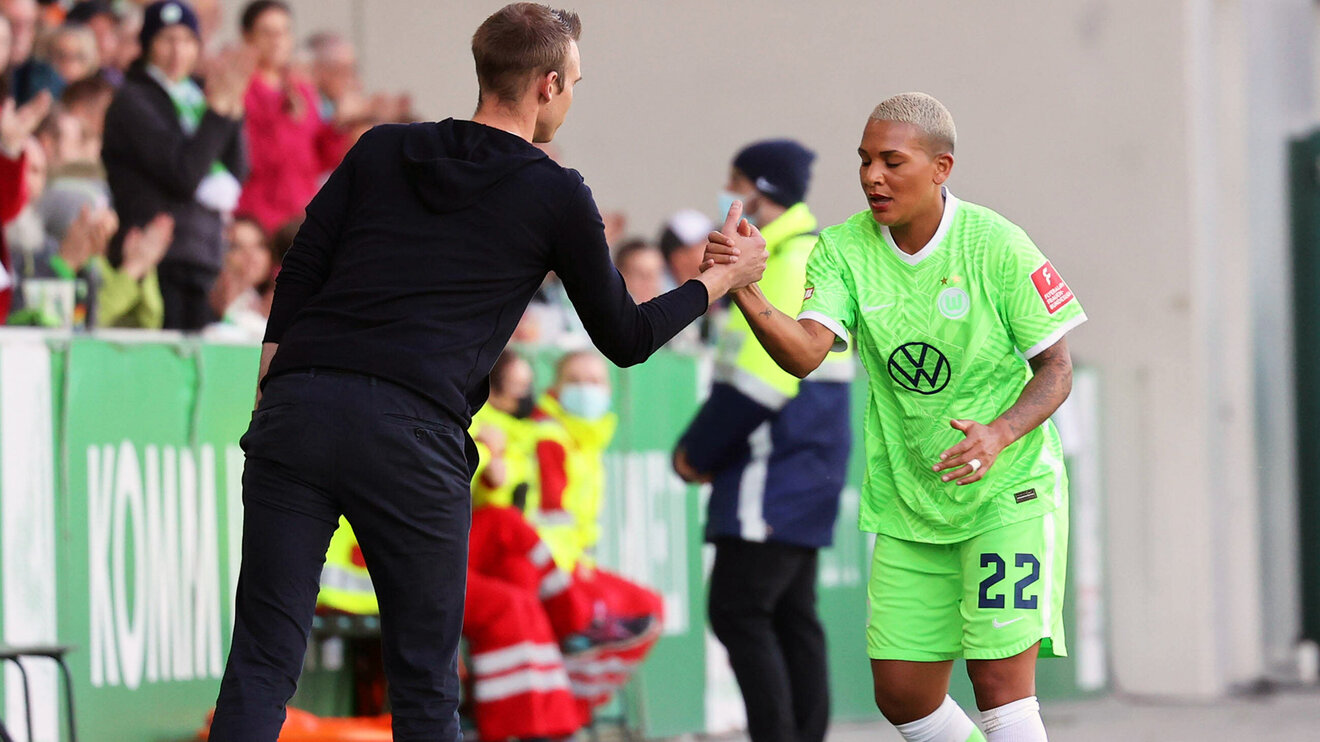 Trainer der VfL Wolfsburg Frauen gibt seiner Spielerin Shanice van de Sanden die Hand.