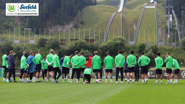 Die Spieler vom VfL Wolfsburg stehen im Kreis auf dem Trainingsplatz.