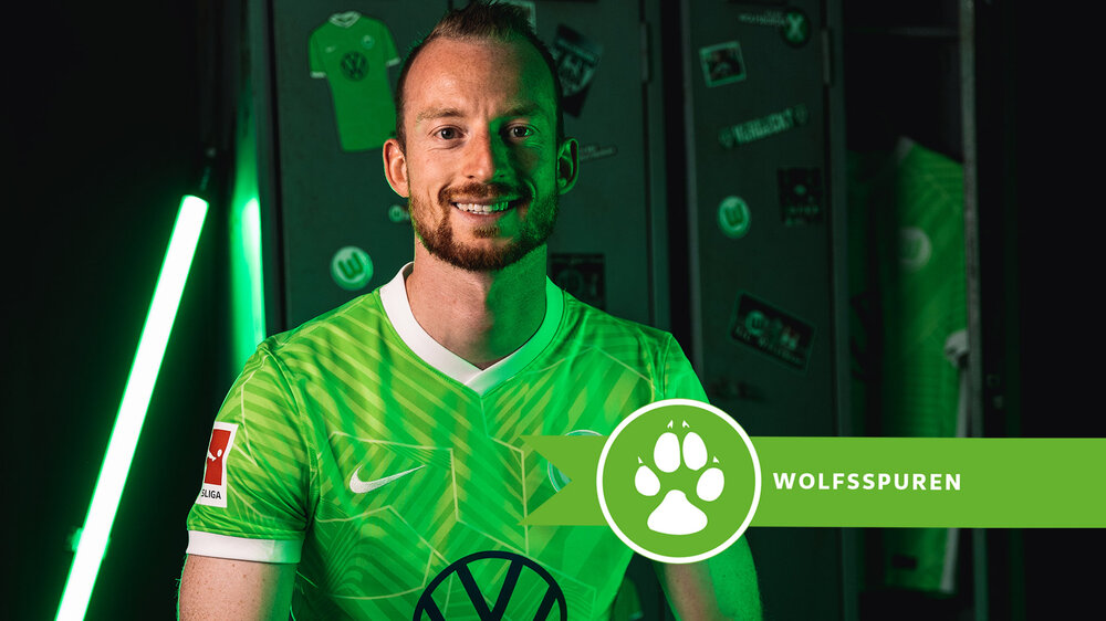 VfL Wolfsburg-Spieler Maximilian Arnold sitzt in der Kabine und lächelt in die Kamera.