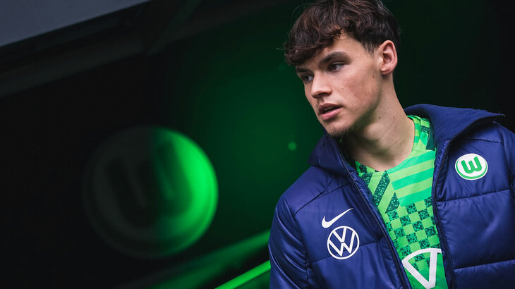 Lukas Ambros geht durch den Spielertunnel des VfL Wolfsburg und schaut in die Volkswagen Arena.