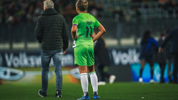 VfL-Wolfsburg-Kapitänin Alexandra Popp steht enttäuscht nach der Niederlage auf dem Rasen.