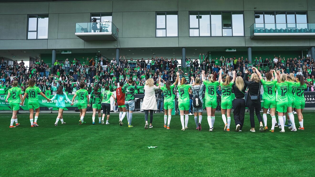 Die VfL-Wolfsburg-Spielerinnen jubeln zusammen mit den Fans.