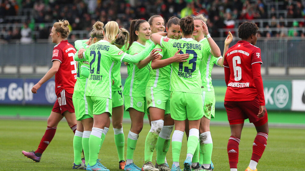 Die Spielerinnen des VfL Wolfsburg jubeln nach einem Tor Arm in Arm.