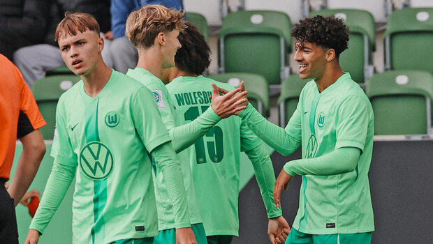 U19-Kapitän vom VfL-Wolfsburg Jonathan Akaegbobi freut sich und klatsch dabei mit seiner rechten Hand bei seinem Mitspieler ein. 