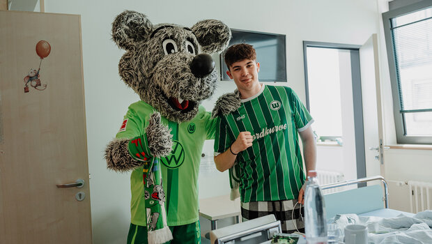 Wölfi und ein Fan im Krankenhaus machen ein Foto zusammen.