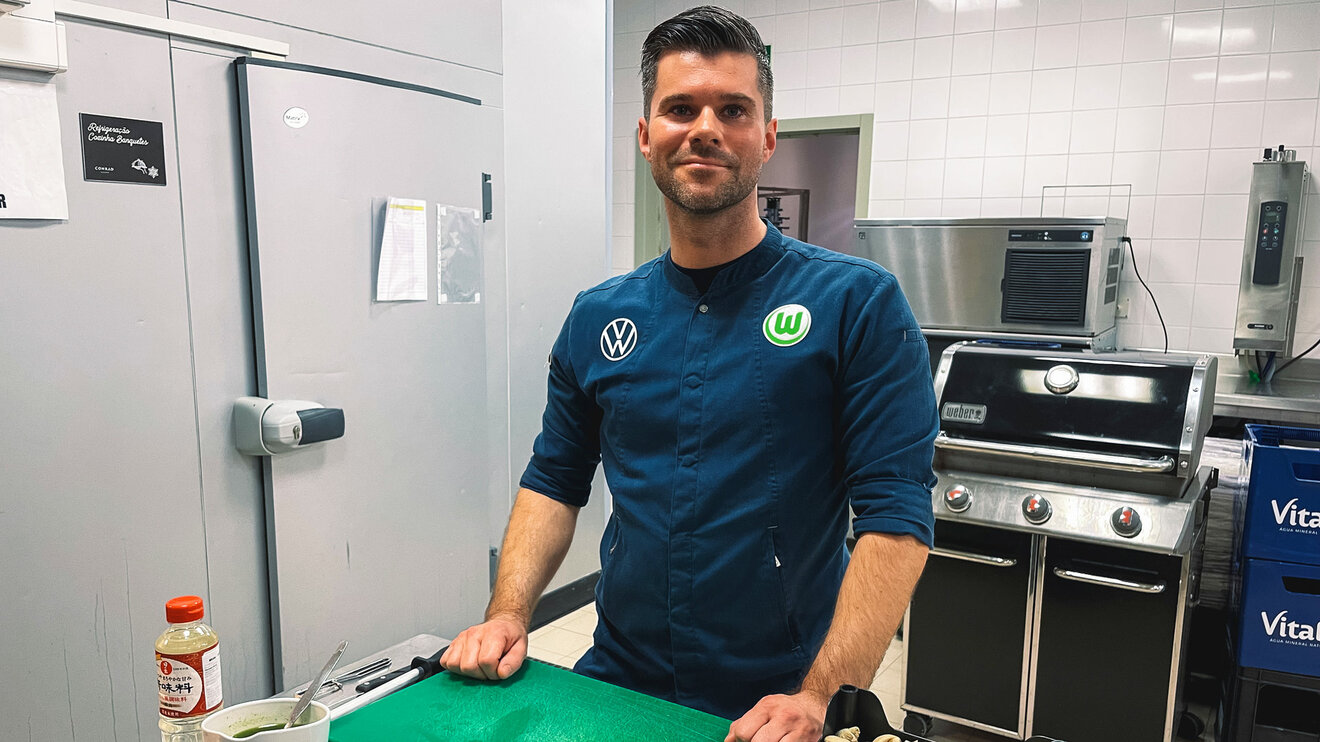 VfL-Wolfsburg-Koch Marvin Mende steht in der Küche.