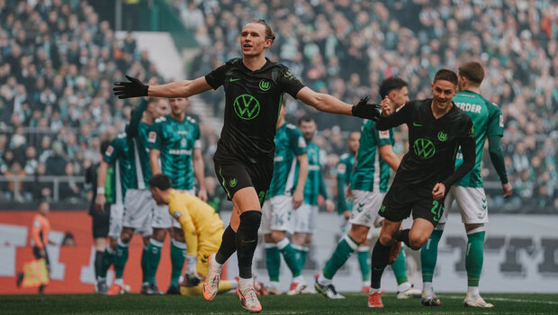 VfL-Wolfsburg-Spieler Patrick Wimmer läuft mit ausgebreiteten Armen über den Platz.