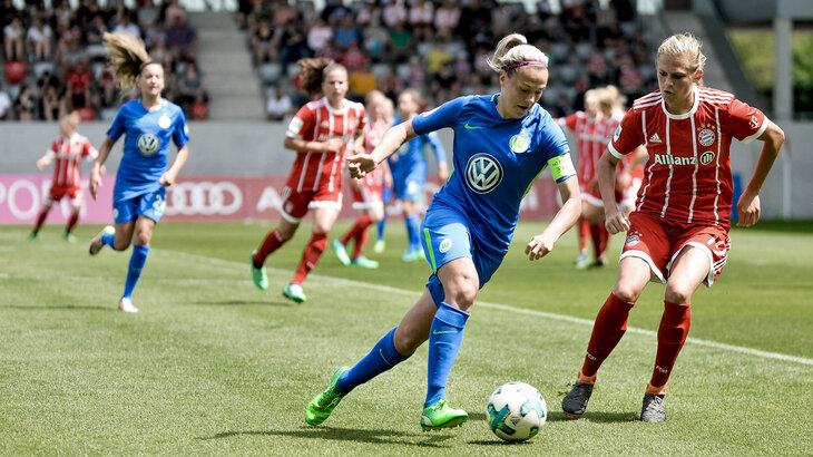 Eine Wölfin nimmt der Spielerin vom FC Bayern den Ball ab.