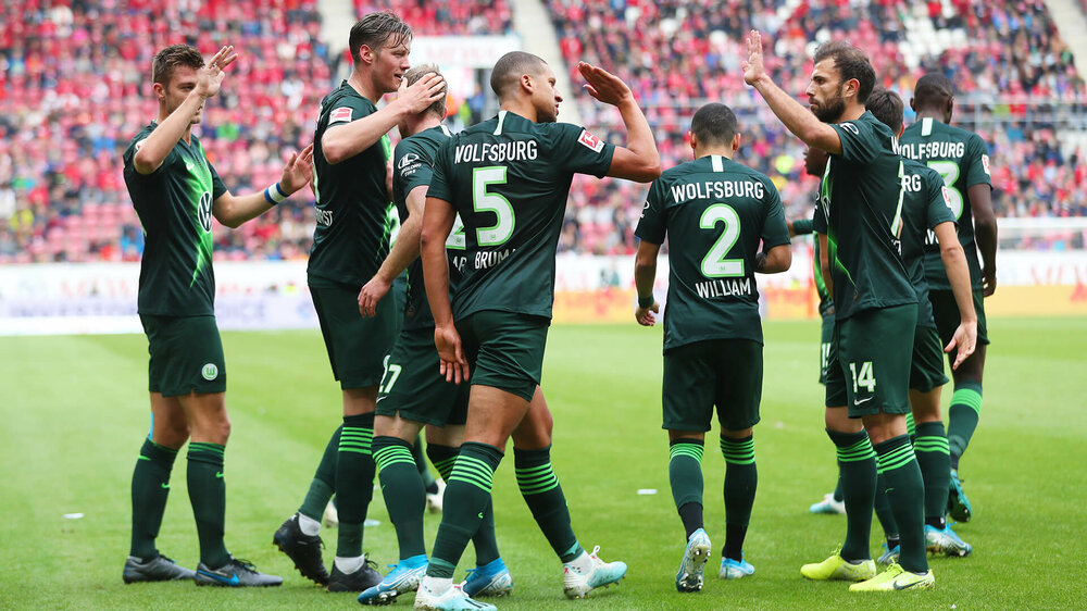 VfL Wolfsburg Spieler klatschen sich ab und bejubeln einen Treffer im Spiel der Wölfe gegen Mainz 05.