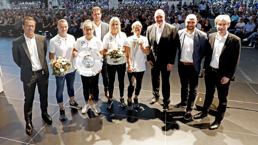Einige VfL-Frauen sind mit dem Pokal und der Meisterschale bei der Betriebsversammlung von VW anwesend. 
