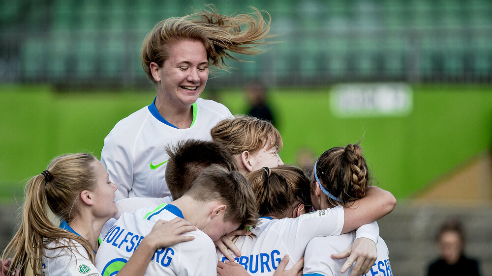 Die Mannschaft der U17 des VfL Wolfsburg Frauen liegen sich jubelnd in den Armen.