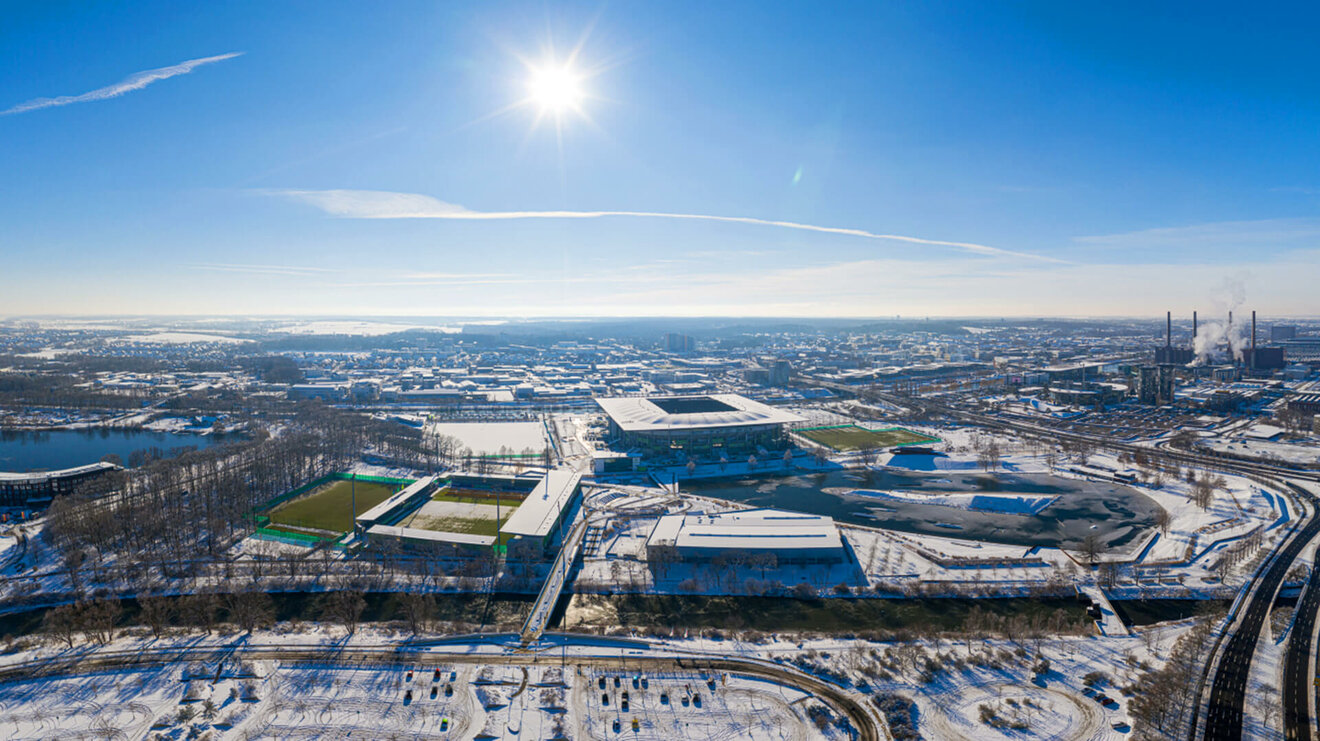 Panoramaaufnahme der Arena und des Allerparks aus der Luft im Winter. 