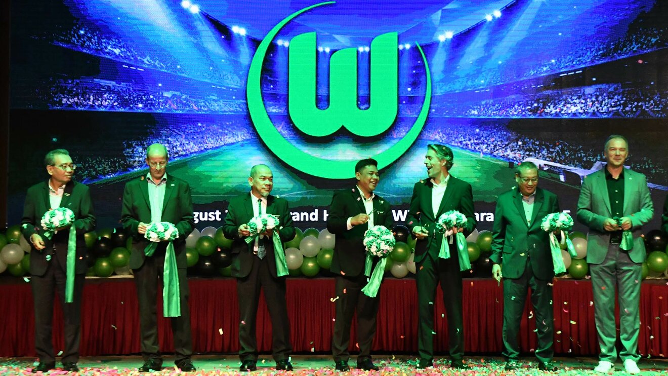Bei der Eröffnung des Büros in Malaysia zerschneidet VfL-Wolfsburg-Geschäftsführer Michael Meeske mit weiteren Personen ein grünes Band.
