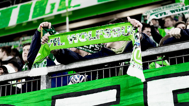 VfL Wolfsburg Fan hält den Schal hoch.