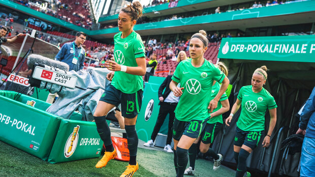 Die VfL-Wolfsburg-Spielerinnen laufen auf das Spielfeld.