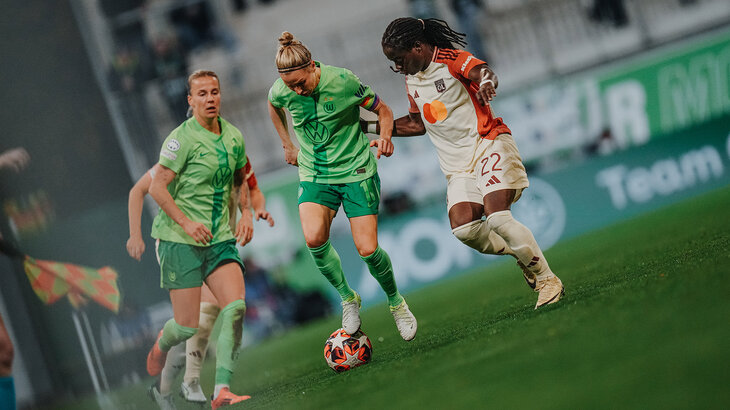 VfL-Wolfsburg-Spielerin Svenja Huth richtet ihren rechten Fuß auf den Ball. Sie ist umgeben von einer Spielern von Olympique Lyon.