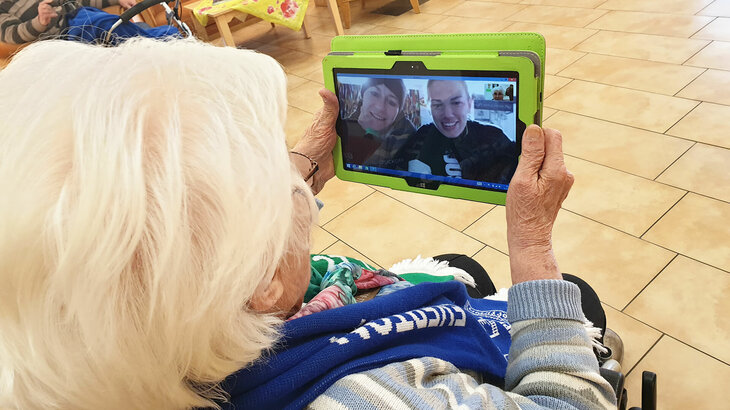 Anna Blässe und Lara Dickenmann im Videogespräch per Tablet mit einer Seniorin.