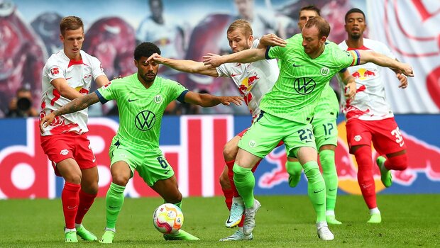 Die beiden VfL-Wolfsburg-Spieler Maximilian Arnold und Paulo Otavio kämpfen mit Gegenspielern um den Ball.