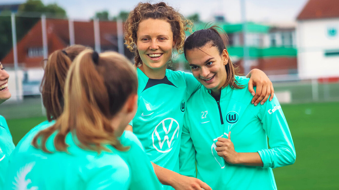 VfL Wolfsburg Spielerin Kalma umarmt eine Mitspielerin beim Training.