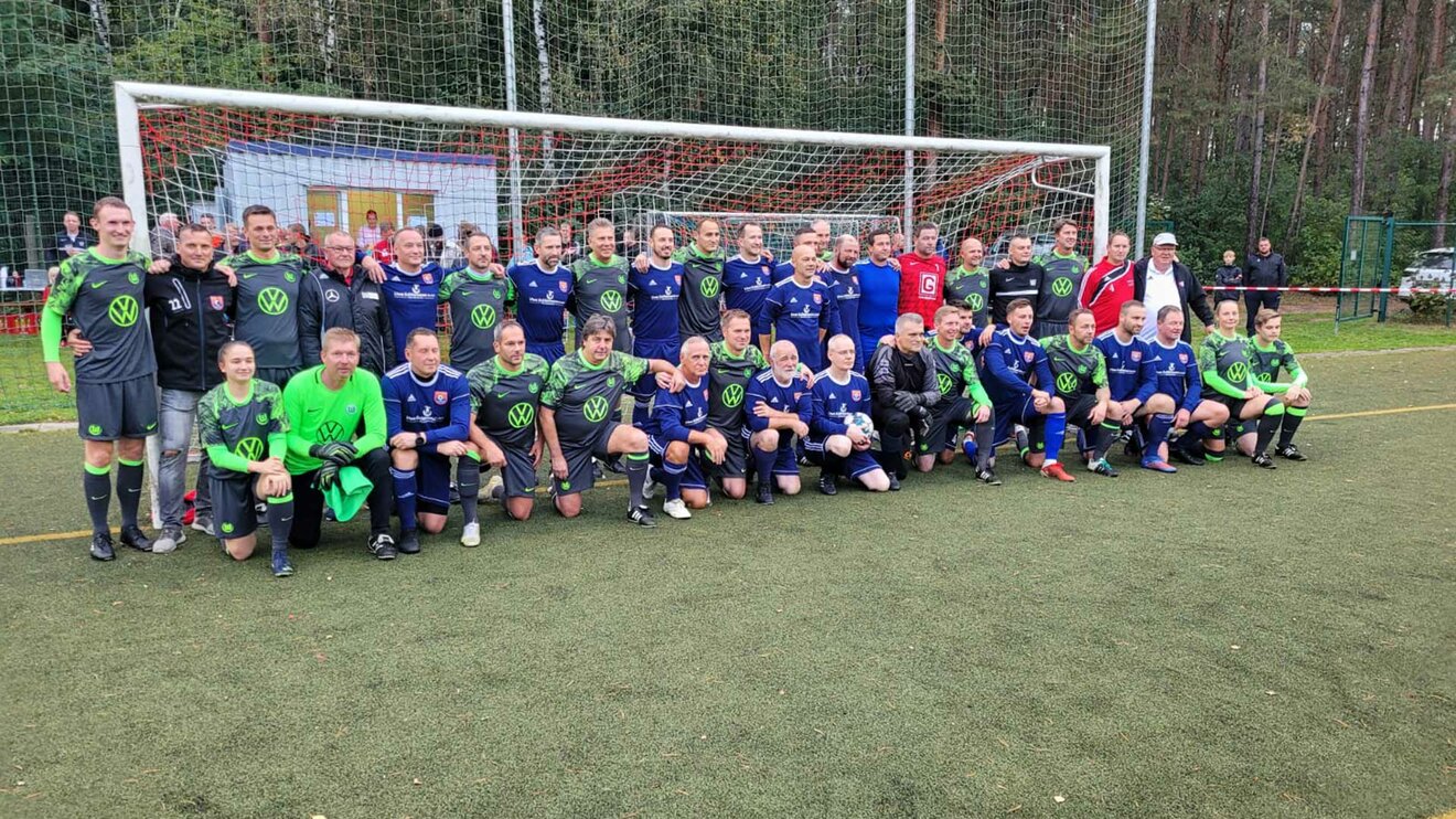 Traditionsmannschaft des VfL-Wolfsburg posiert mit dem Team des FSV Heide im Tor nach einem Benefizspiel.